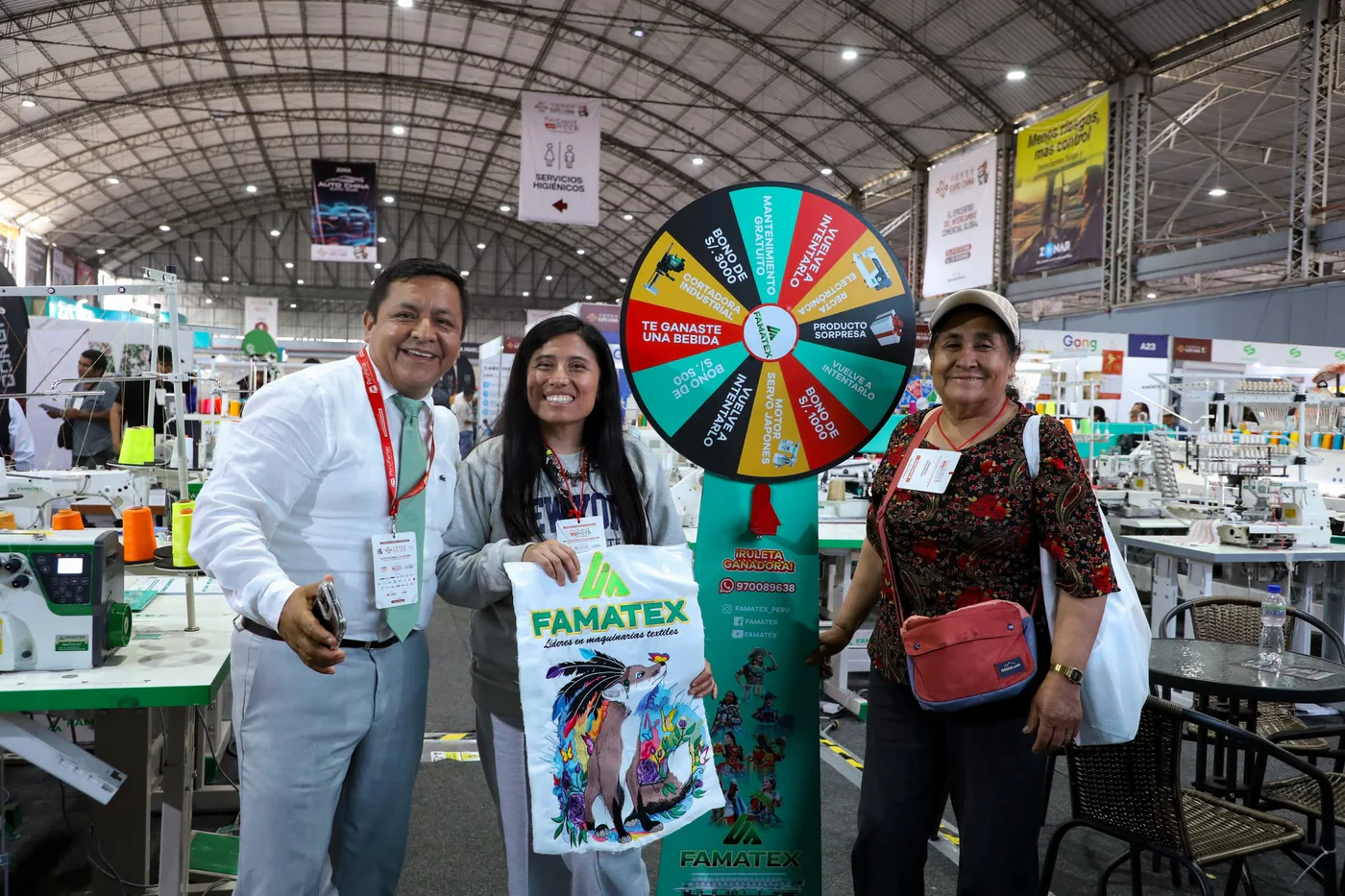 Ganadores celebrando junto a la ruleta de premios FAMATEX en una feria
