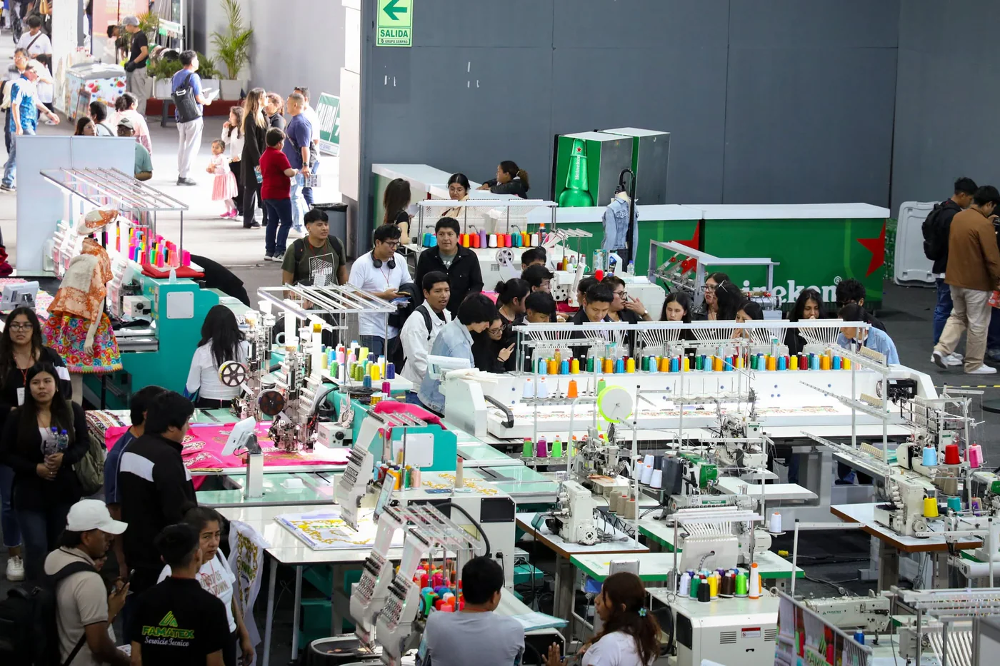 Bordadoras FAMATEX funcionando en una feria, rodeadas de visitantes